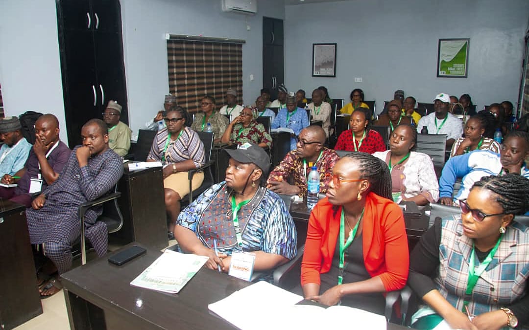 Participants seated at desks following a session, with printed materials in front of them.