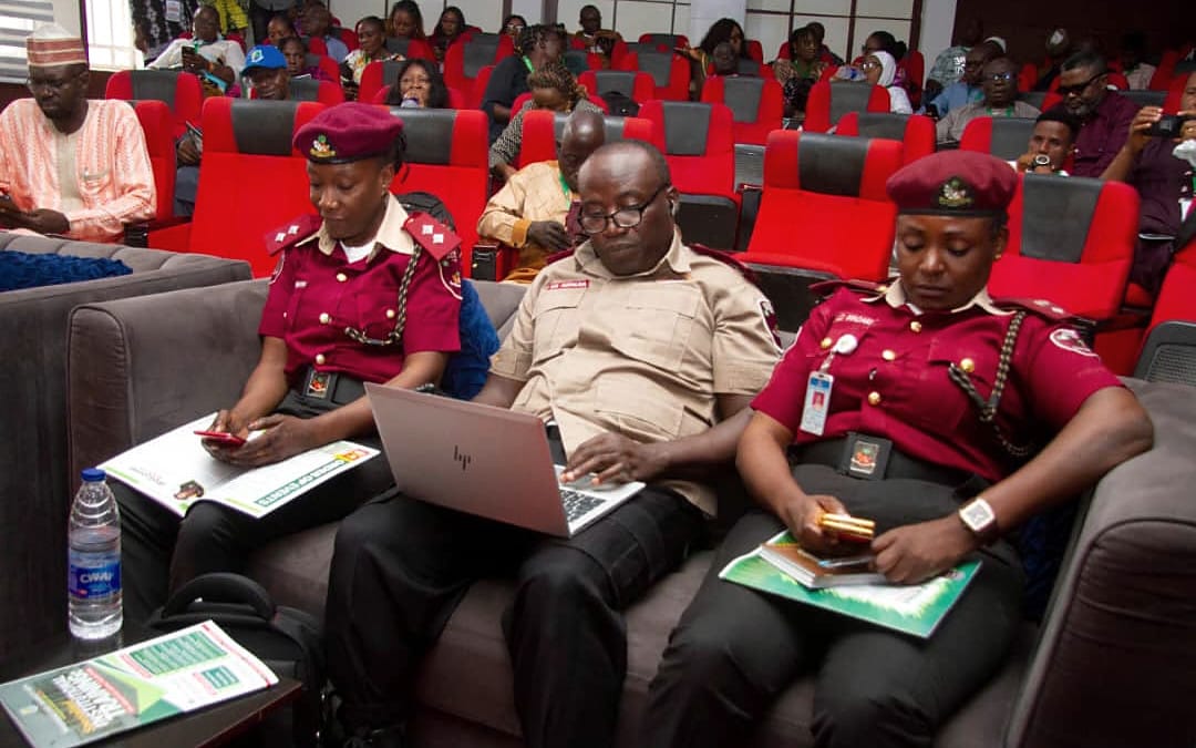 Delegates and uniformed officials seated in an auditorium.
