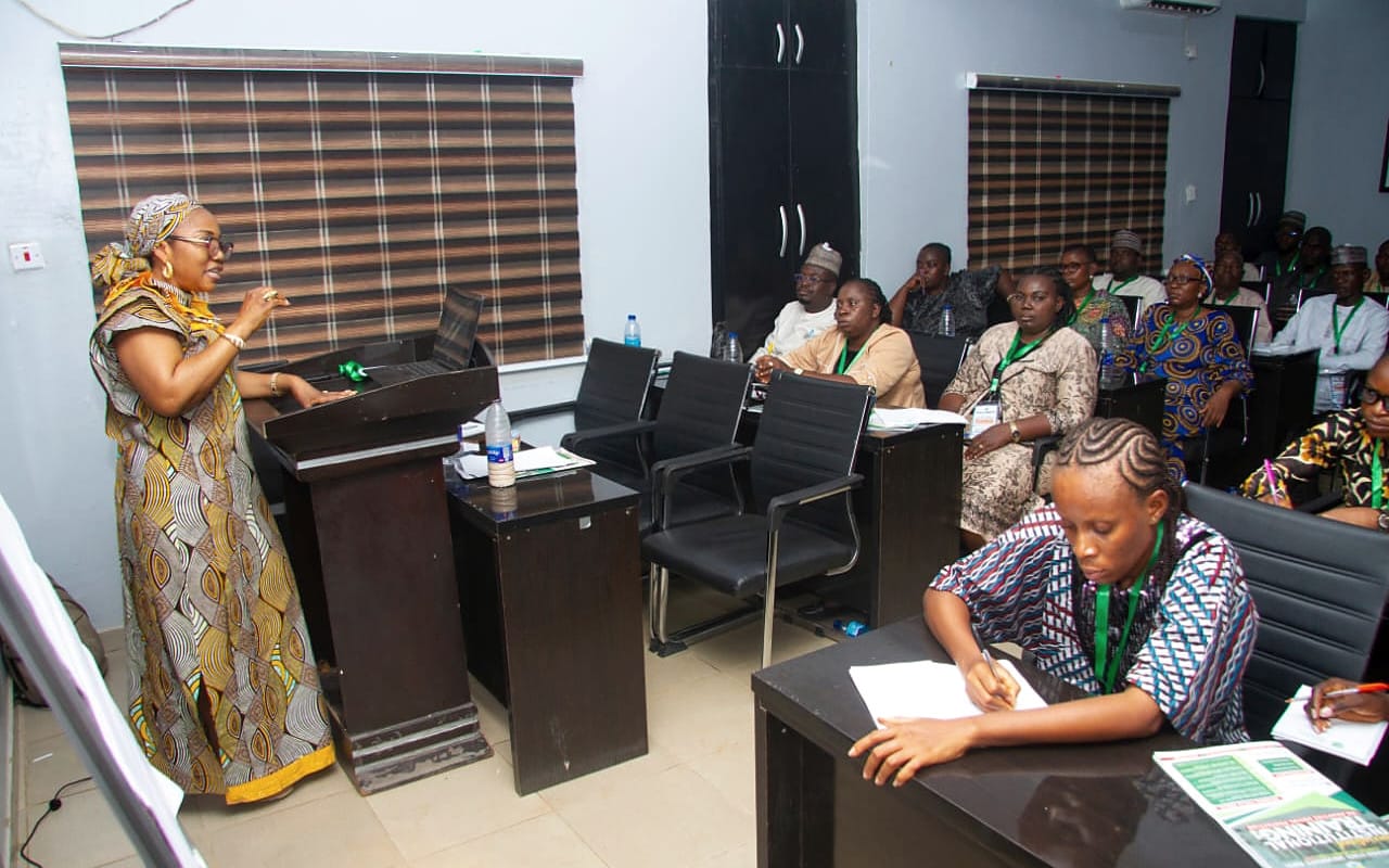 A facilitator leading a small-group session with participants at desks.