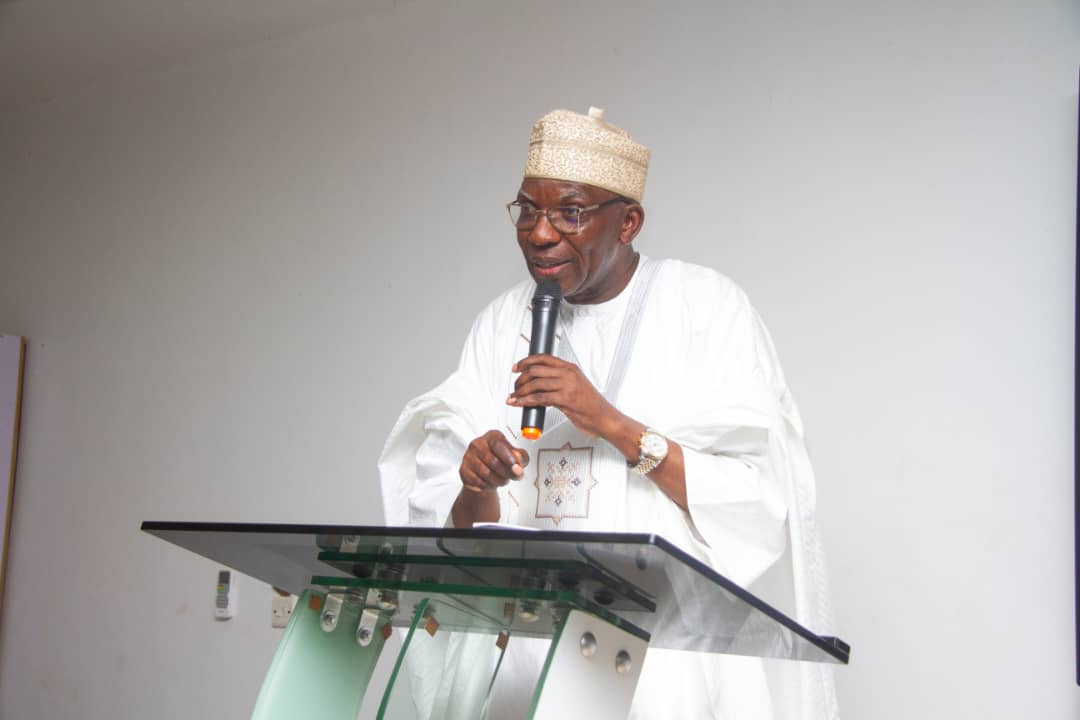 A facilitator presenting beside a screen showing a slide on budget preparation.