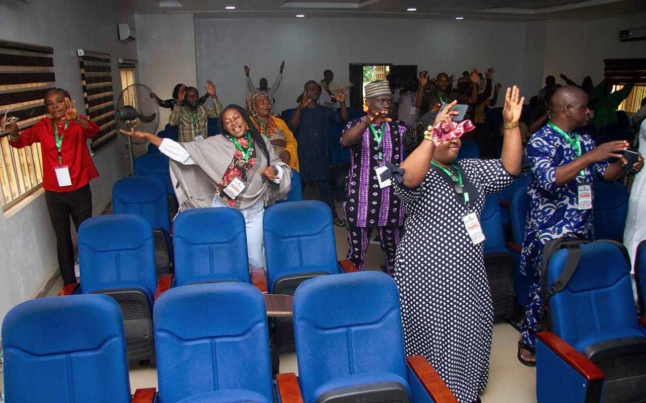 Participants standing with raised hands during an interactive session.