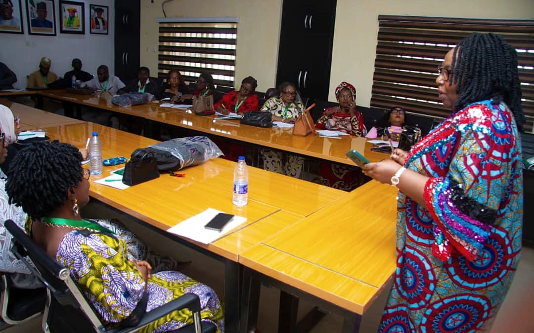 A facilitator addressing colleagues seated around a boardroom table.